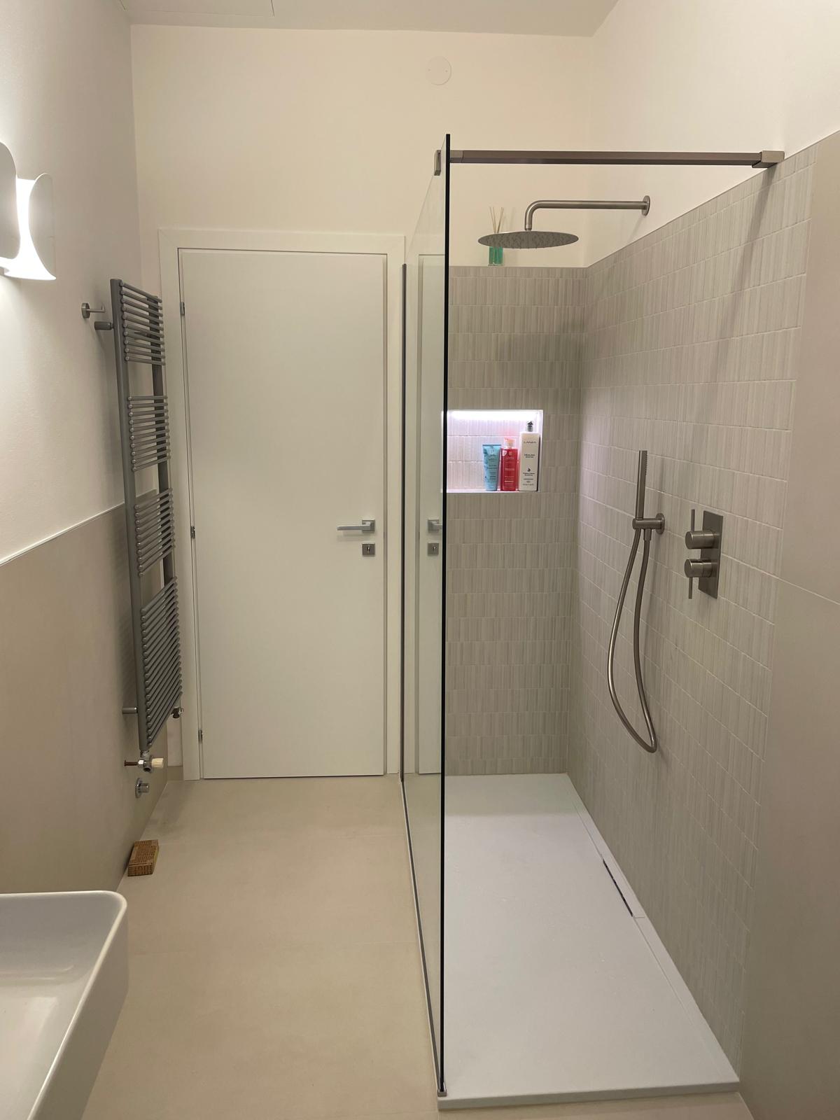 Doccia walk-in moderna con soffione a pioggia, nicchia illuminata e scaldasalviette installata a Padova
