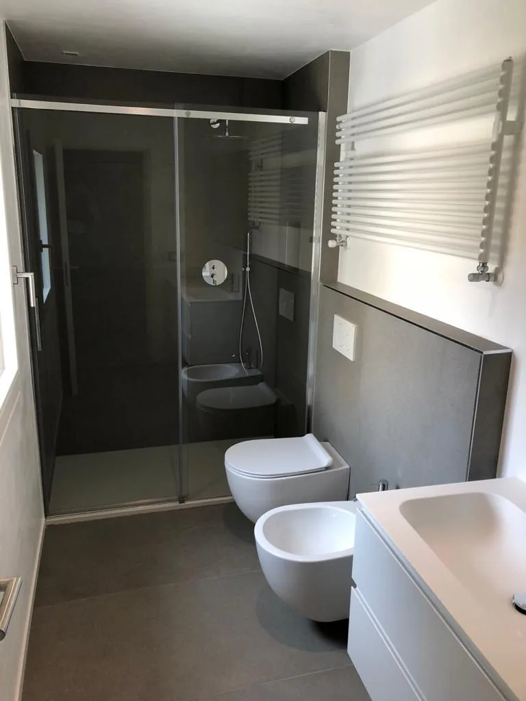 Bagno moderno realizzato da Brugnolo Termoidraulica a Padova con doccia scorrevole e scaldasalviette bianco