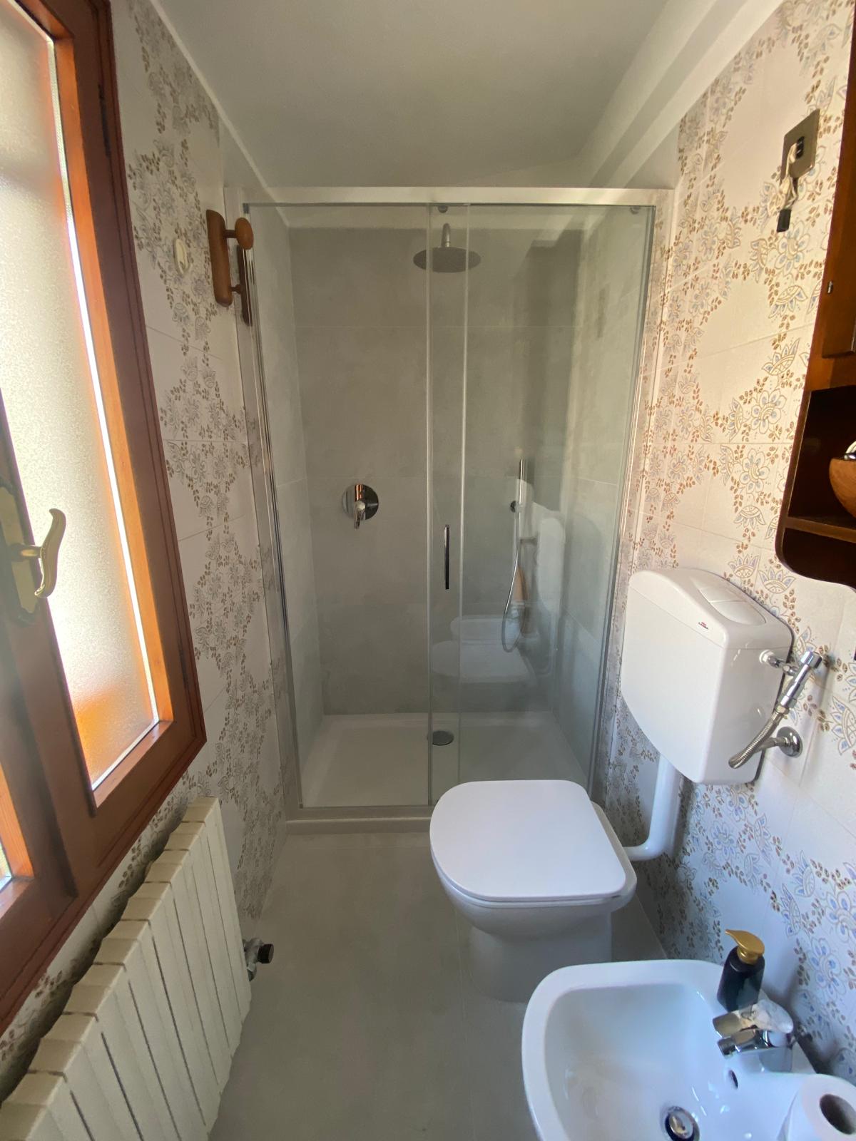 Bagno con nuova doccia in vetro dopo la trasformazione della vasca